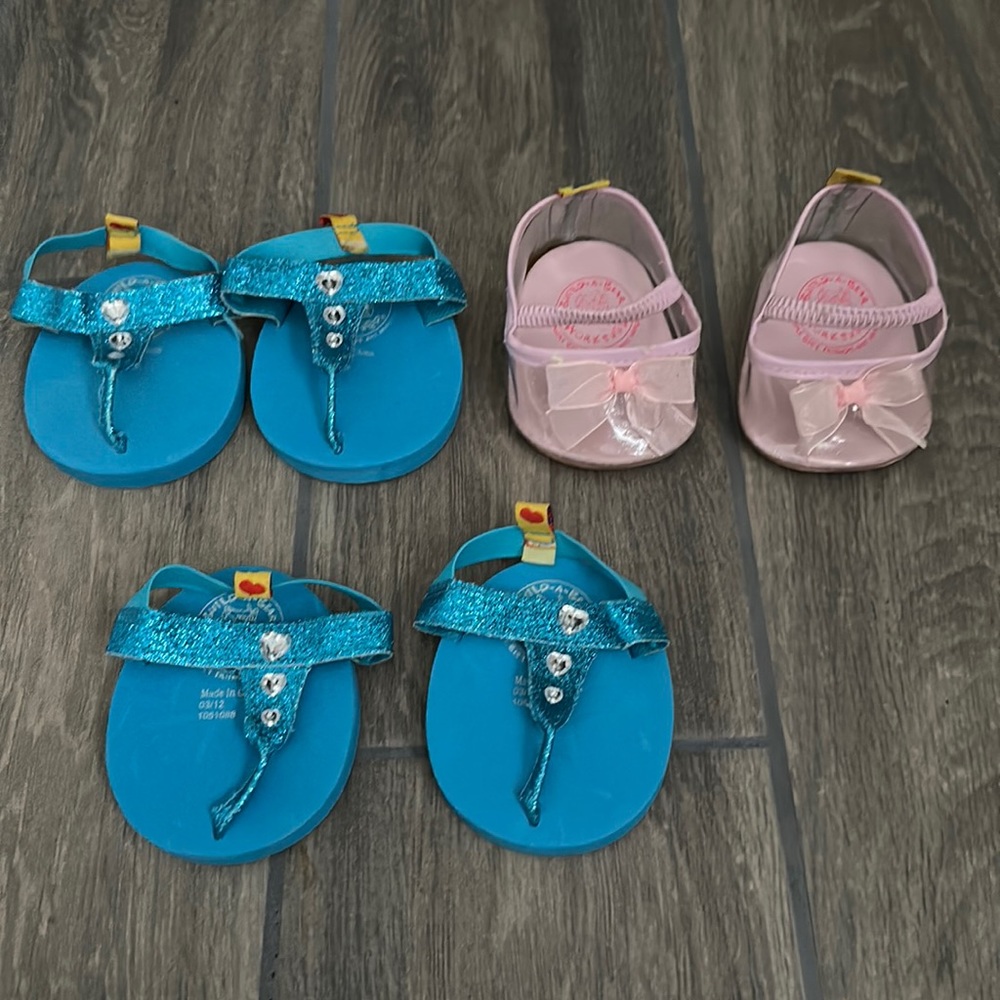 Build a Bear shoes.  2- Blue set of flip flops and a set of high heels, pink.
